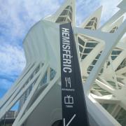 Señalética exterior con texto, pictograma e indicador direccional.