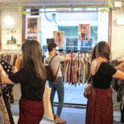 personas mirando ropa en mercadillo